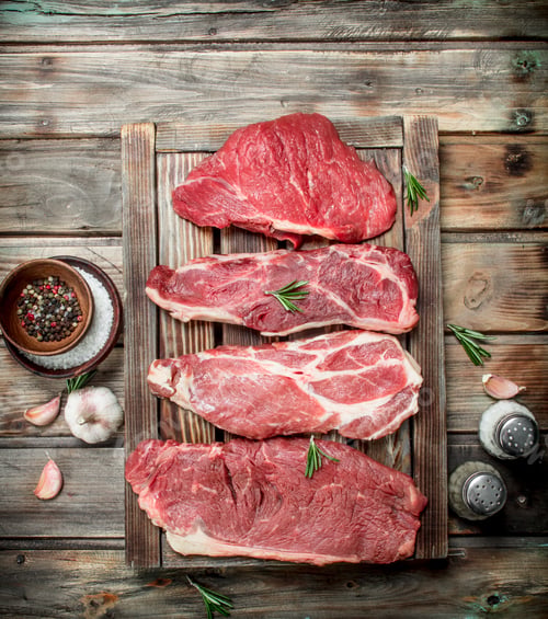 Preview: Raw meat. Beef steaks and pork with spices.