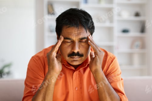Preview: Closeup of mature indian man touching temples