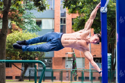 Preview: Hot young muscular man working out on horizontal bars