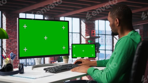 Preview: Black male worker in his loft using copy space PC to analyze sales reports