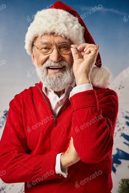 Preview: stylish good looking man in Santa costume posing with glasses and crossed arms, Merry Christmas