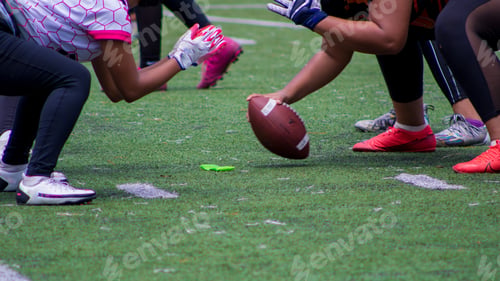 Preview: Closeup shot of American football players kicking off a match on a green field