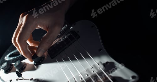 Preview: Musician playing the electric guitar. Close-up of a man's hand turning the volume slider on the