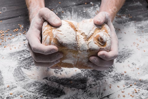 Preview: Bakery concept background. Hands hold bread loaf