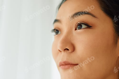 Preview: Close-up of young Asian woman looking away.