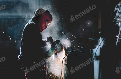 Preview: Man works with grinder cutting metal.