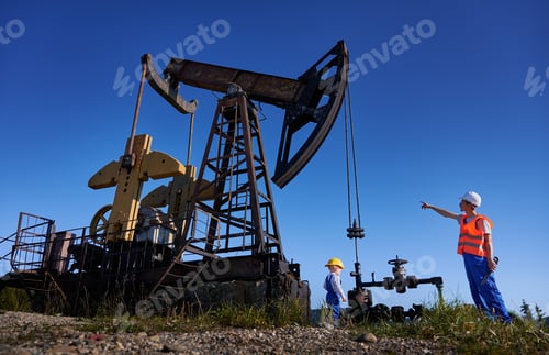 Preview: Mechanic showing operation of petroleum rig to small male child.