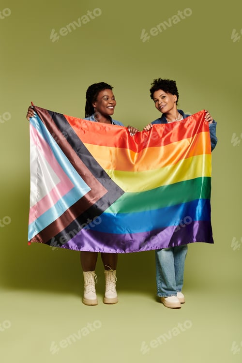 Preview: Loving lesbian couple proudly displaying a vibrant pride flag in a stylish urban setting