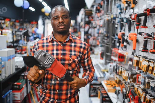 Preview: A african american man chooses a power tool in a hardware store