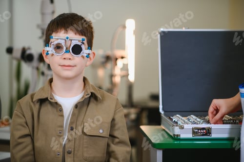 Preview: Boy undergoing eyesight examination with trial frame in ophthalmology clinic