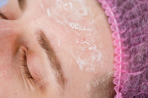Preview: Portrait of young man on cleaning face procedure by woman cosmetologist in beauty clinic