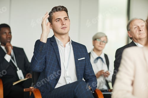 Preview: Young businessman sitting at seminar