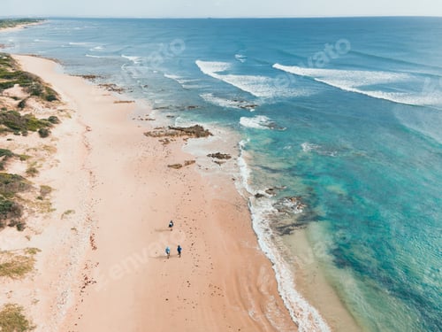 Preview: Aerial view of group of fisherman seen walking along coastline