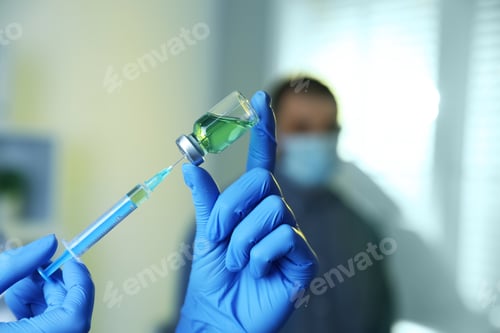 Preview: Doctor filling syringe with medication in clinic, closeup. Vaccination and immunization