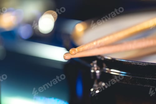 Preview: Close-up, snare drum and drumsticks on a dark background.