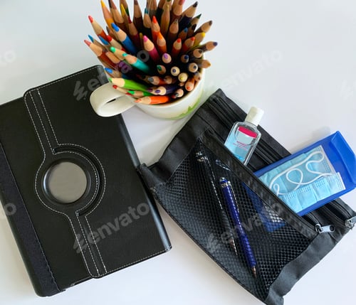 Preview: Overhead of the new normal for back to school during corona virus pandemic. Facemasks and sanitizer.