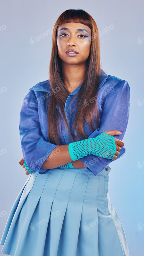 Preview: Arms crossed, fashion and portrait of a trendy woman isolated on a blue studio background. Confiden