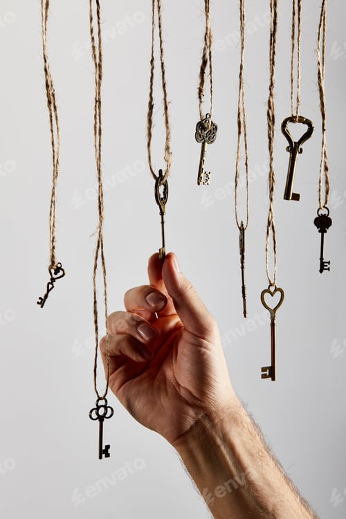Preview: cropped view of man touching vintage keys hanging on ropes isolated on white
