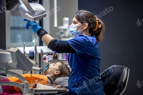 Preview: Young female dentist in dental office. Dentist at work. Dental treatment concept.