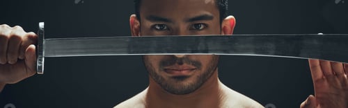 Preview: Shot of a handsome young man standing alone in the studio and posing with a broadsword