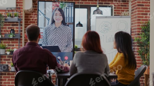 Preview: Group of coworkers using video call communication in boardroom