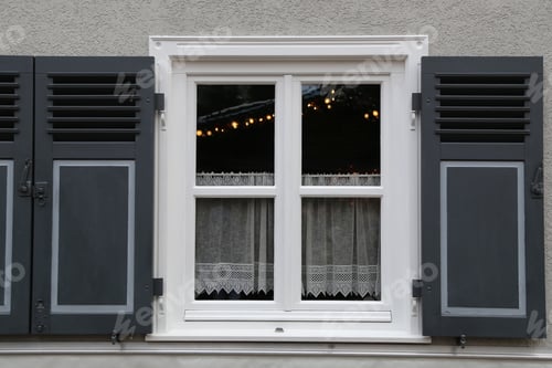 Preview: Closeup of a white framed window with a small white curtain