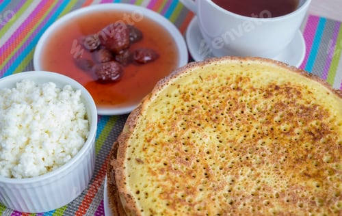Preview: Pancakes with strawberry jam, cheese and cup of tea.