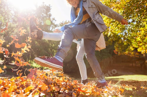 Preview: Friends kicking autumn leaves