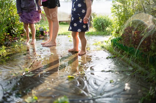 Preview: children play in puddle in summer after rain. kids fun in countryside.
