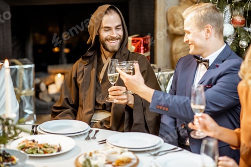 Preview: Elegantly dressed people having a festive dinner indoors