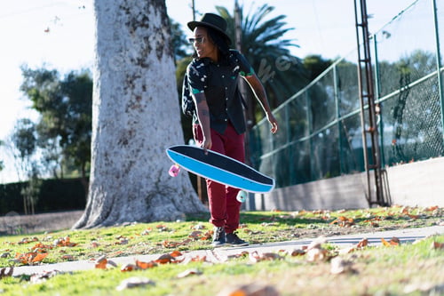 Preview: Woman holding skateboard in park