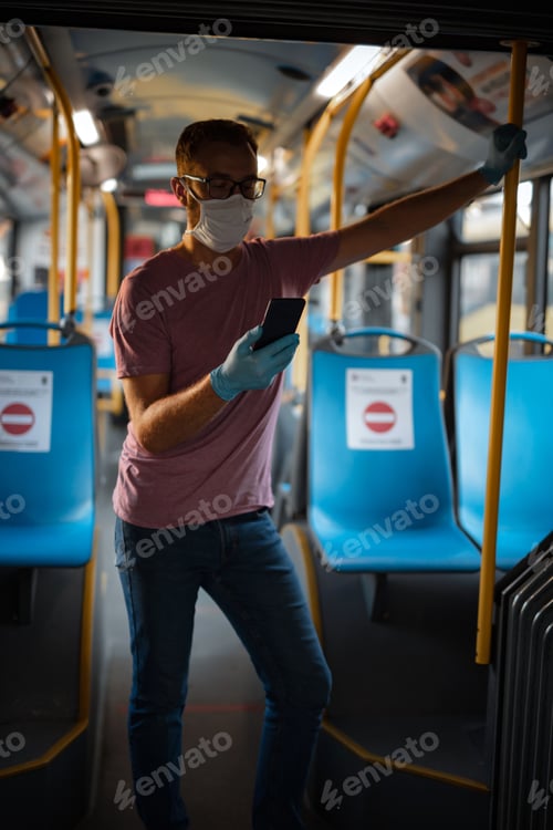 Preview: Man With Medical Protective Mask And Gloves Standing In An Emtpy Bus.