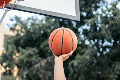Preview: Close-Up of Hand Holding Basketball Near the Hoop