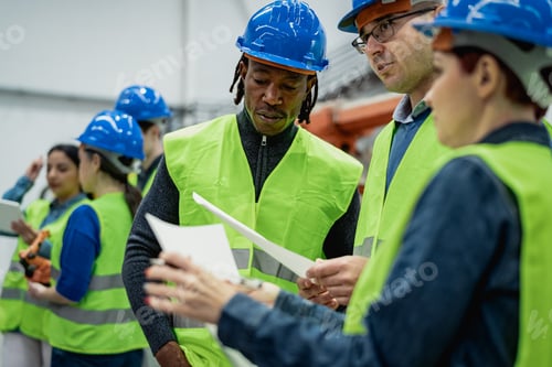 Preview: Team of multiracial engineers working in robotic factory - Tech industry concept