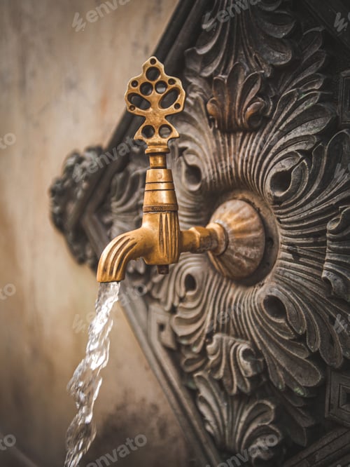 Preview: Tap is releasing a stream of crystal clear water which flowing over an antique metal molding