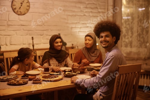 Preview: Happy Muslim man and his extended family having dinner at dining table.