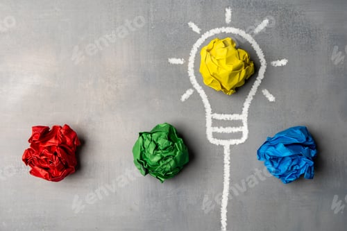 Preview: A flat lay image of a lightbulb drawn on a chalkboard with crumpled pieces of paper.