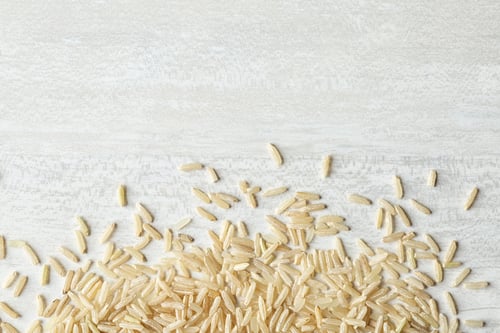 Preview: Brown rice on wooden background, top view with space for text