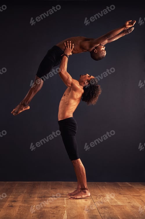 Preview: Two male contemporary dancers performing a dramatic pose in front of a dark background