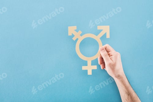 Preview: cropped view of male hand with white paper cut gender sign on blue background, lgbt concept