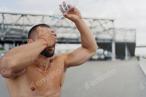 Preview: Exhausted sportsman splashes fresh cold water over head.