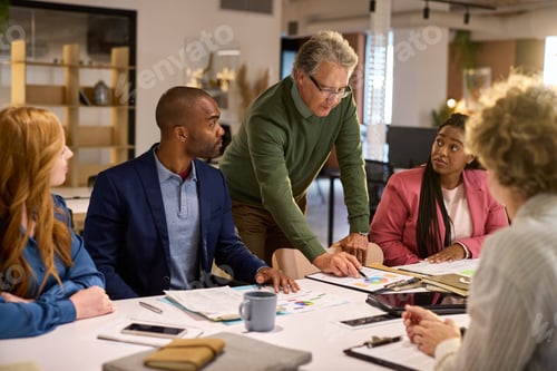 Preview: Mature man giving presentation in boardroom