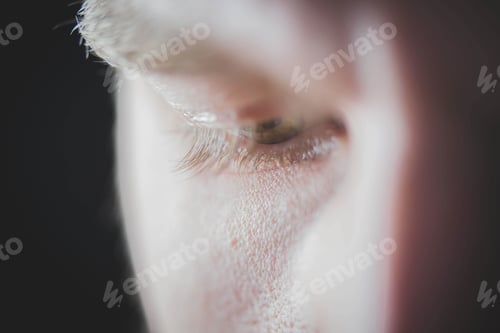 Preview: Selective focus closeup of a male's eye looking down - concept of being sad