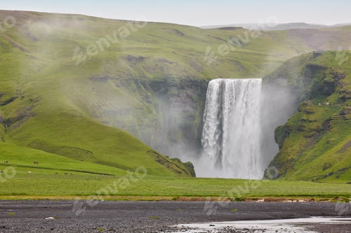 Preview: Picturesque Skogafoss waterfall surrounded by green pasture. South area. Iceland