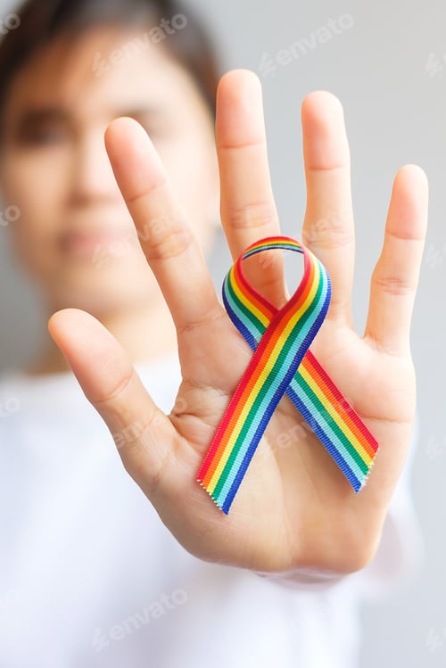 Preview: hand holding LGBTQ Rainbow ribbon for Support Lesbian, Gay, Bisexual, Transgender and Queer communit