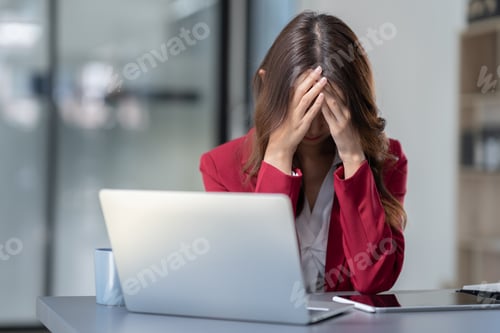 Preview: Asian businesswoman sitting in office stressed and fatigued from overwork on financial matters on of