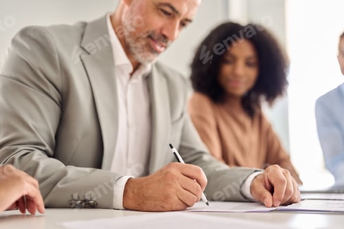 Preview: Senior businessman ceo investor wearing suit signing business legal document.