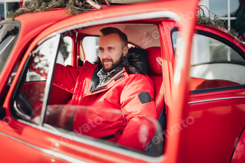 Preview: Bearded young gentleman in a stylish red car
