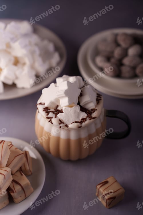 Preview: Cozy scene with creamy hot drink, star marshmallows, chocolates, and sweets creating warmth.