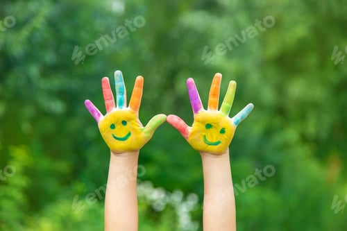 Preview: Child hands in paints a smile. Selective focus.